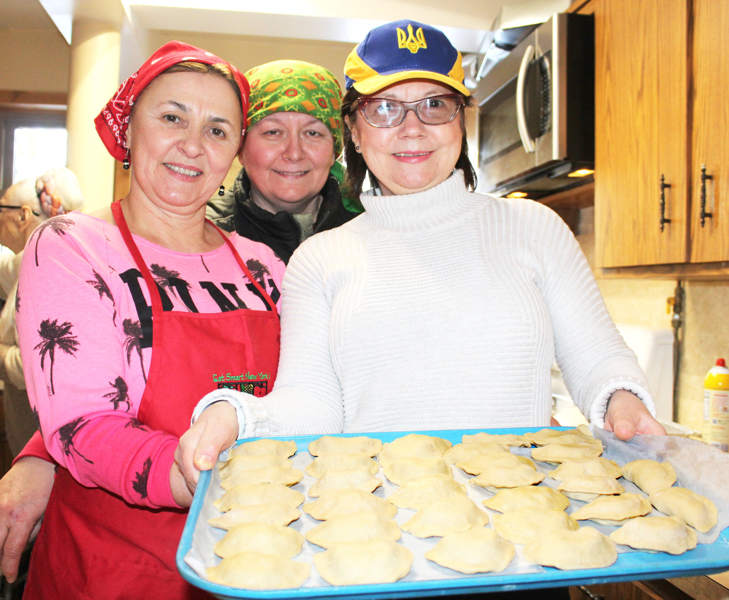 Irina Malyuk, Maria Nakonczna and Lubo Nakonechna carry one of the last trays of pierogi from the assembly area into the kitchen. A good time was had by all.